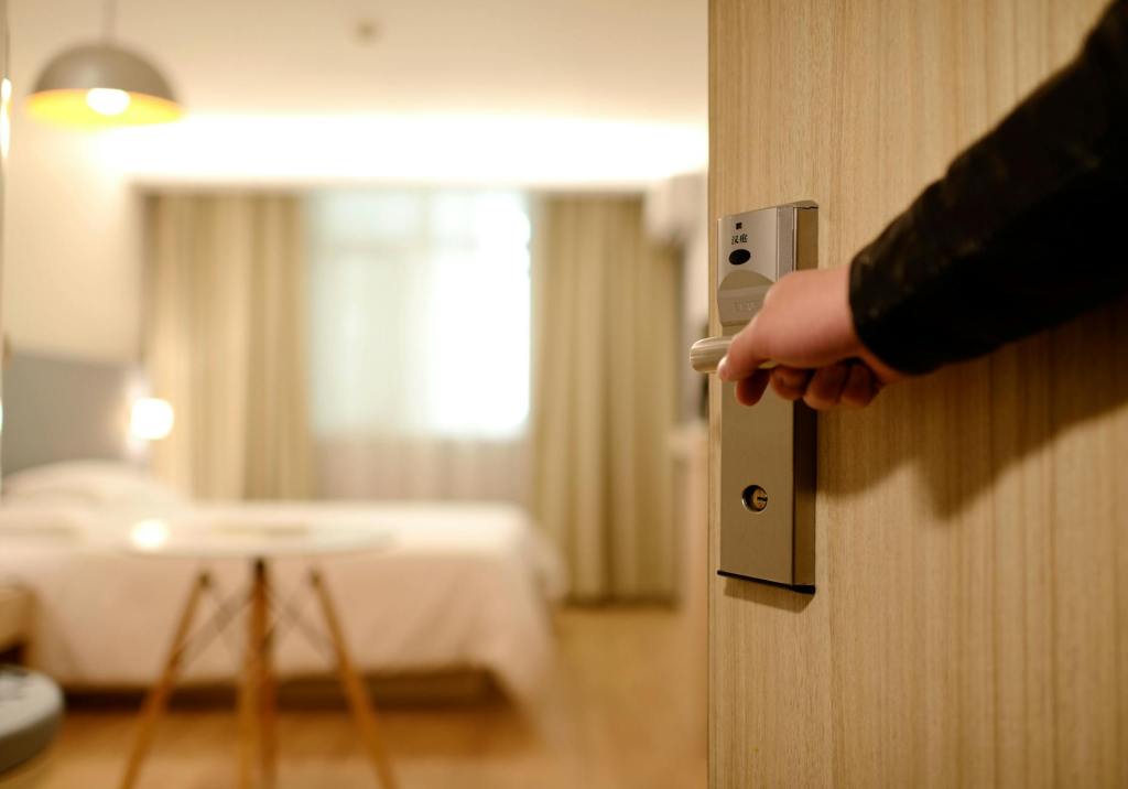A hotel staff member opening a hotel room door